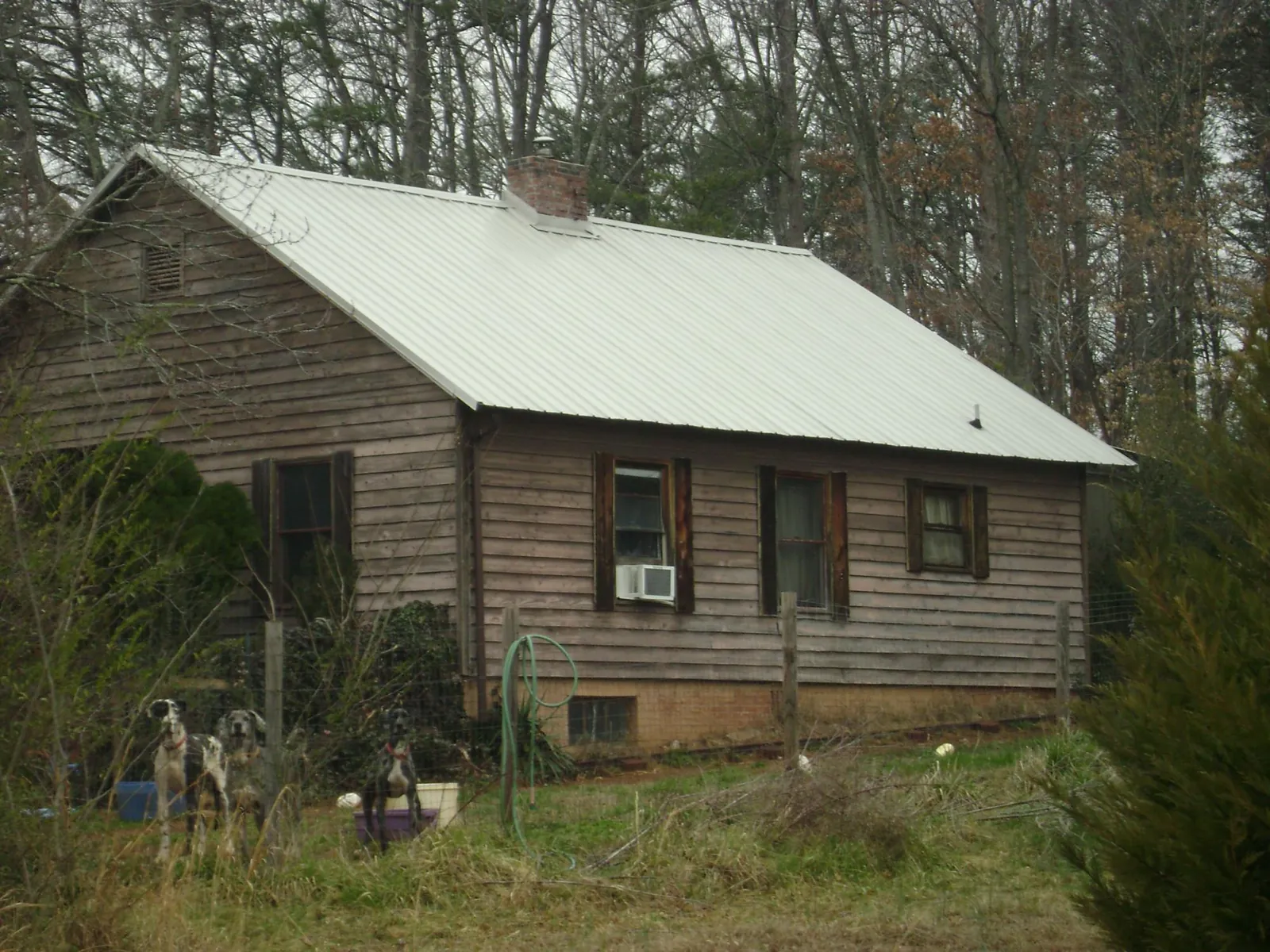 White metal roof on an old wood sided farmhouse, from a Metal Roof Installation job in Sweet